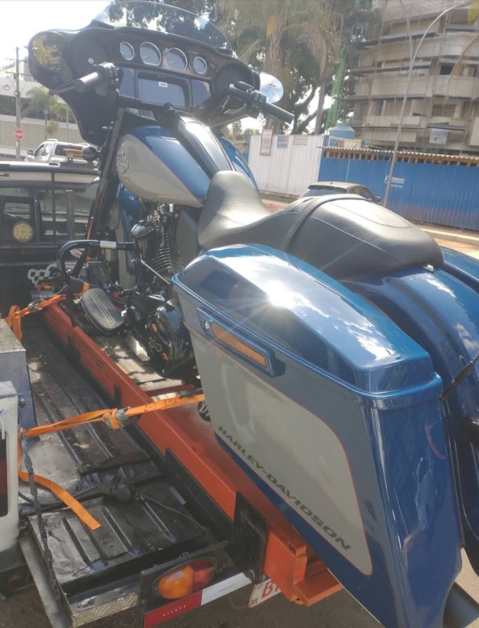 Harley-Davidson azul e prata transportada com segurança na plataforma do guincho