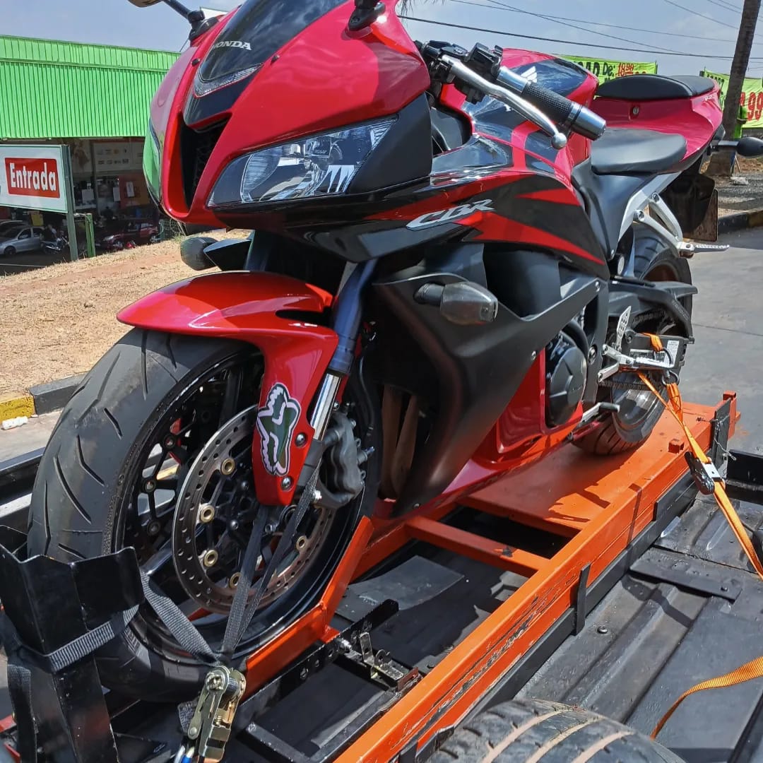 Honda CBR 600RR vermelha presa na plataforma com amarração profissional